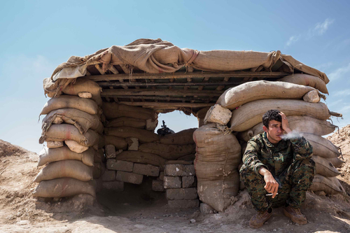 Irak - Un jeune combattant yézidi s'octroie une cigrette devant sa position d'observation. © Giacomo Sini